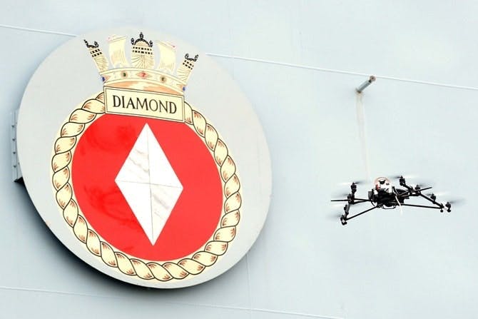 Drone flying in front of HMS Diamond nameplate